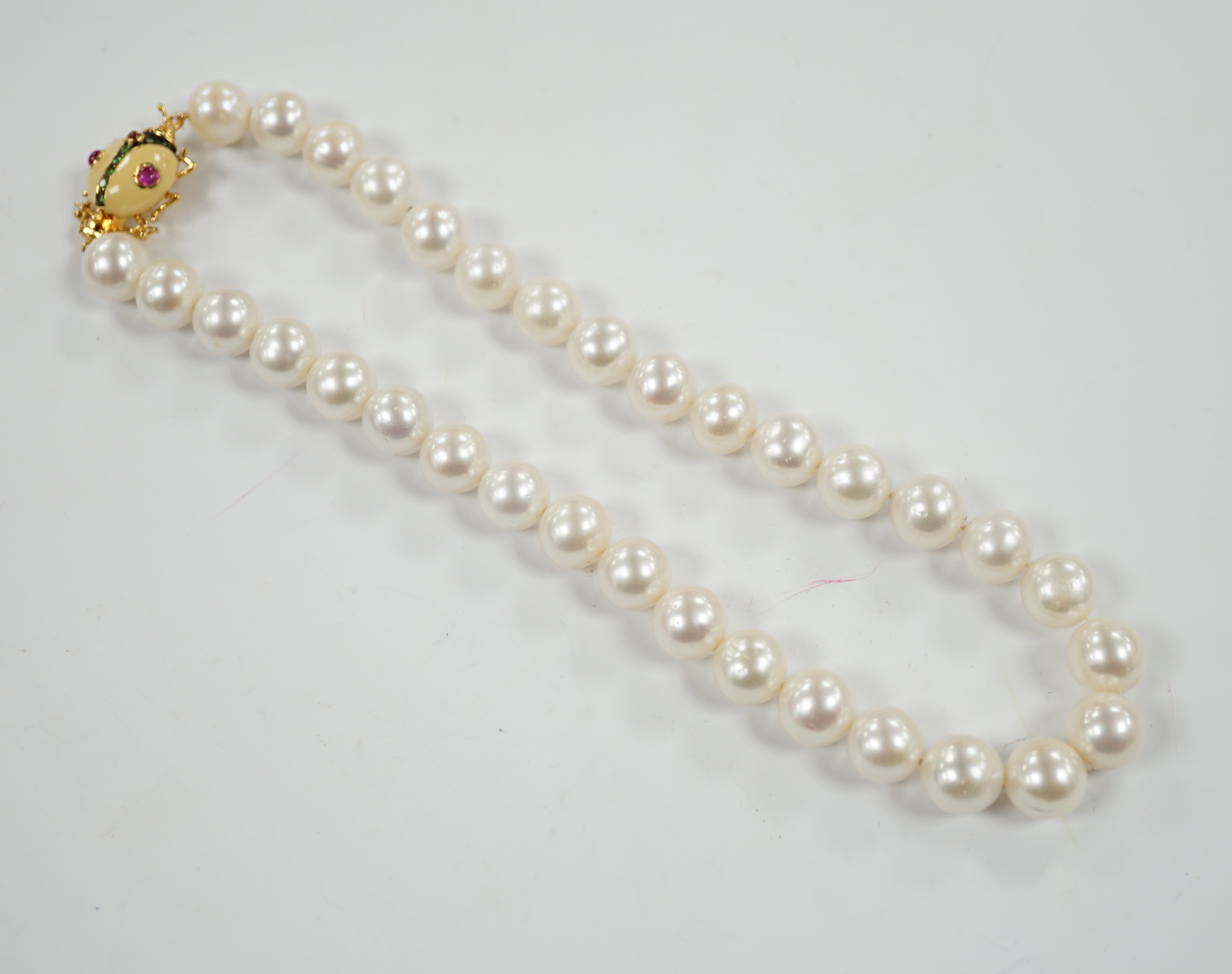 A Butler & Wilson single strand cultured pearl necklace, with enamelled and gem set bug clasp, 43cm.